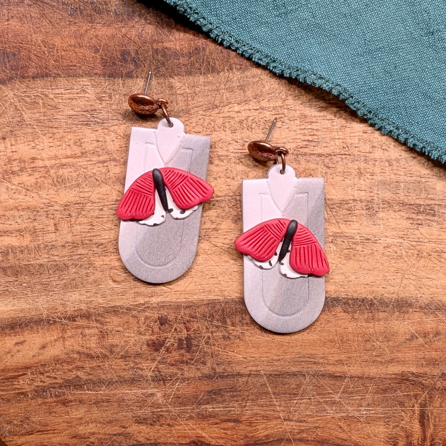 Red and Black Moth Earrings on Grey Marble